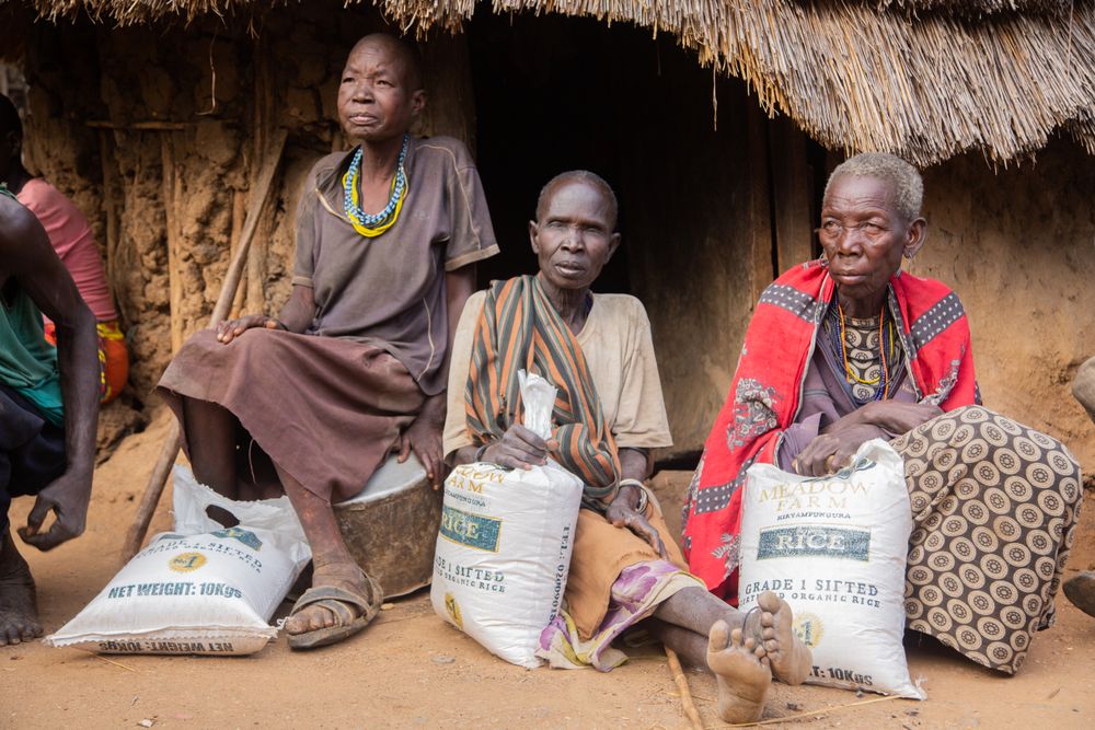 African women seated with rice aid packages